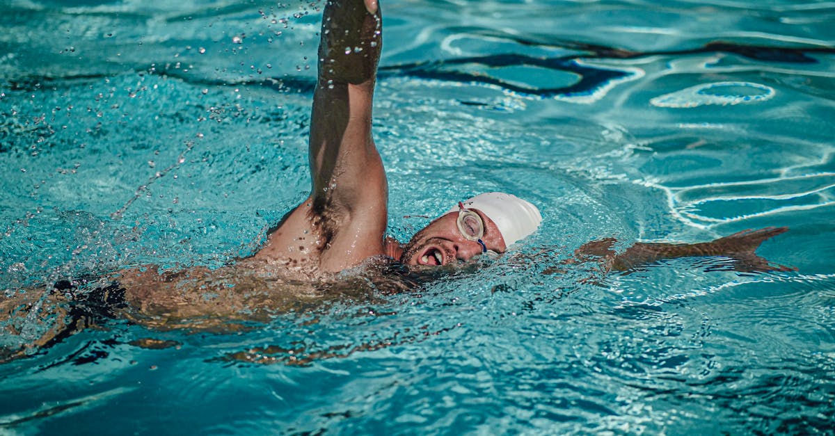 Dynamic shot of a male swimmer practicing freestyle with focus on technique and skill.